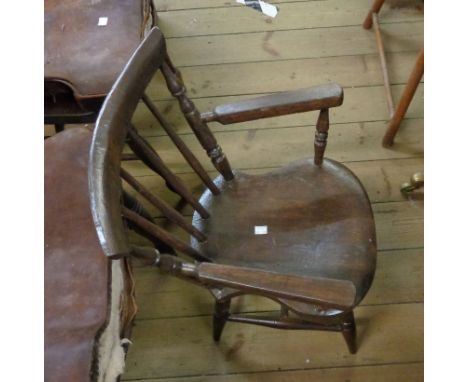 An old child's stick back elbow chair with later finish and moulded solid seat, set on turned supports