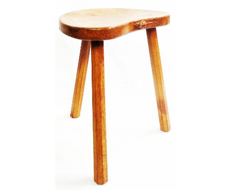 A Robert (Mouseman) Thompson oak stool with shaped seat featuring carved mouse to edge, set on triple rustic faceted legs