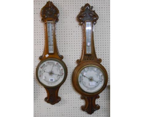 Two similar late Victorian carved oak cased banjo barometer/thermometers, both with aneroid works and printed ceramic dials -