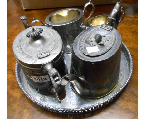 A silver plated circular gallery tray containing a Victorian three piece tea set and another teapot