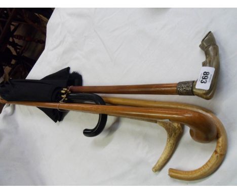 A selection of walking canes and an umbrella including horn handled and silver mounted horse hoof stick, antler handled, etc.