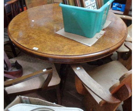 A 1.17m diameter figured walnut veneered breakfast table, set on a carved base with bulbous pillar and scroll tripod base