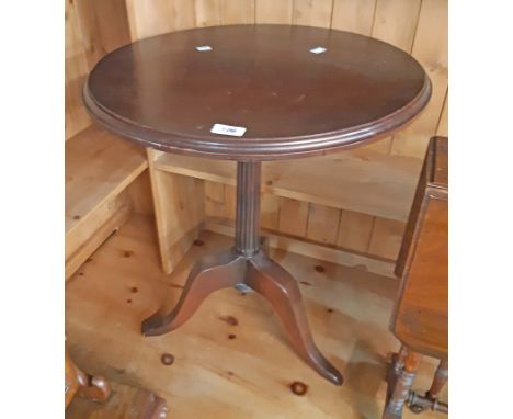 A stained wood pedestal wine table, set on fluted pillar and tripod base