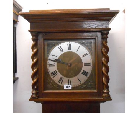 A vintage oak longcase clock with flanking barley twist decoration to hood and visible pendulum, with weight driven gong chim