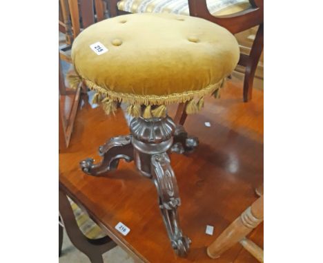 A Victorian carved rosewood revolving piano stool with upholstered circular seat and screw action, set on ornate tripod base
