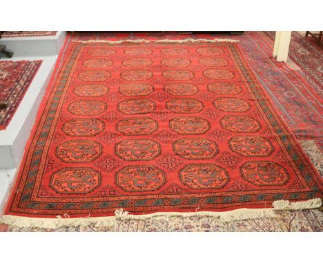 A red ground carpet with stylized decoration 11' 9" x 8' 3".