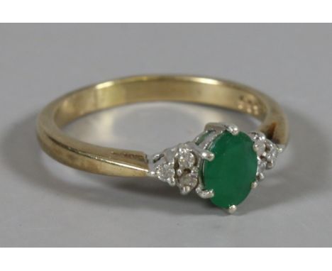 A ladies 9 carat gold ring set with an emerald and diamond set shoulders, size R.