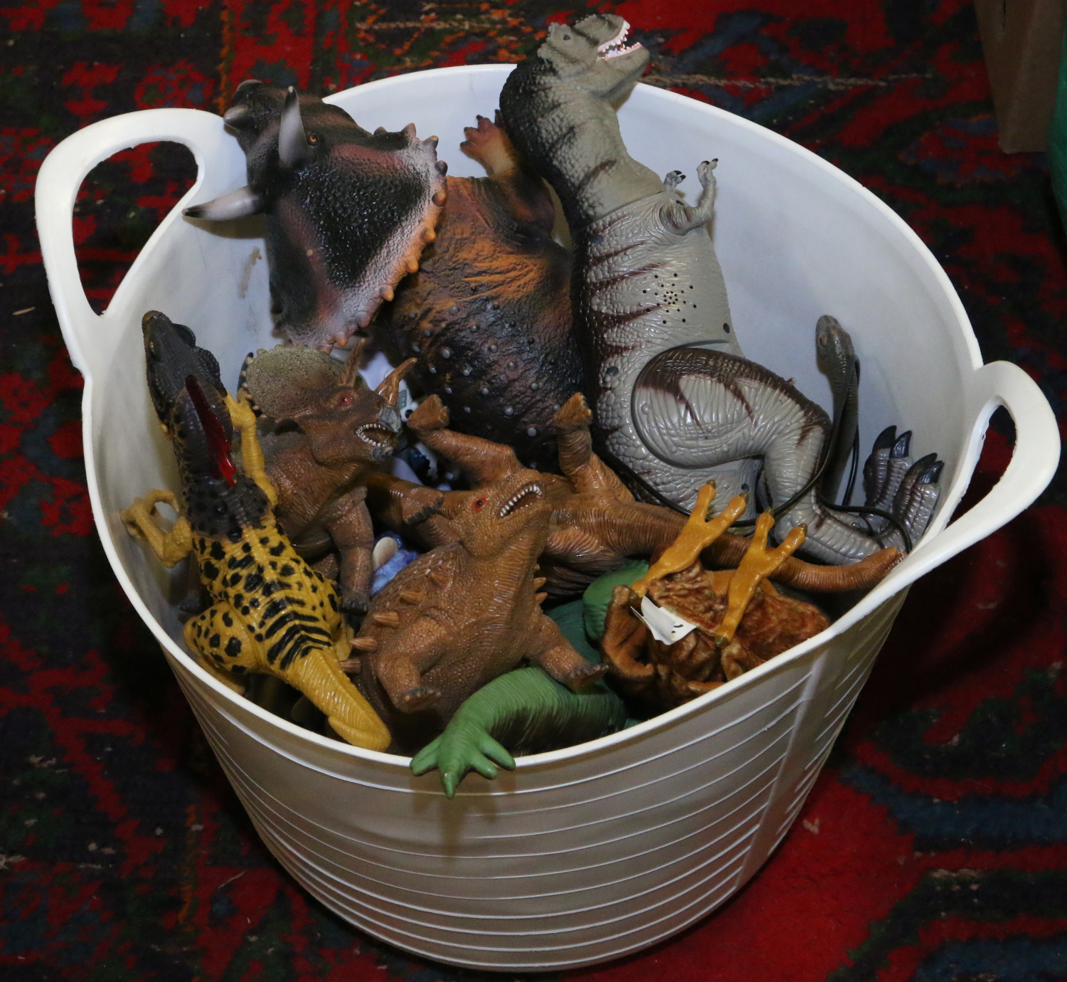 A plastic bucket of model dinosaurs.