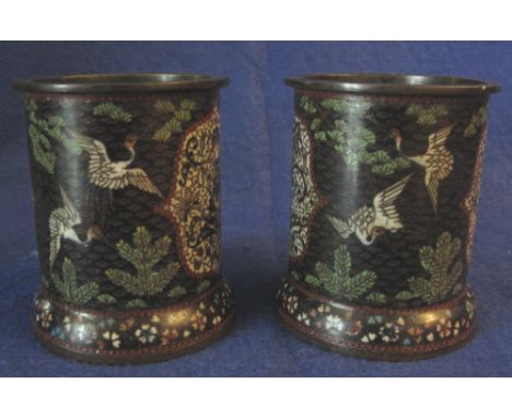 Pair of Japanese cloisonne short cylindrical vases, decorated with floral panels and cranes flying amongst pine branches and 