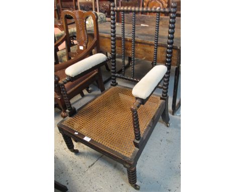 Early 20th Century stained, padded elbow chair with cane seat on bobbin turned frame and supports.(B.P. 24% incl. VAT)