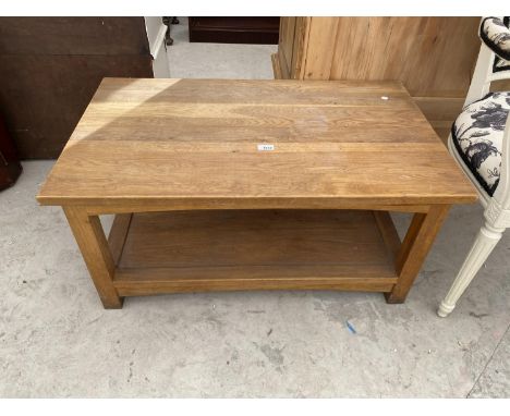 AN OAK COFFEE TABLE WITH LOWER SHELF 