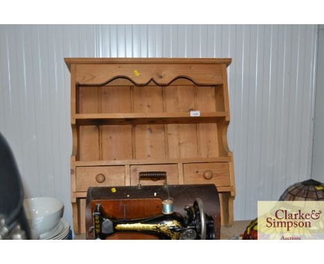 A pine wall shelf fitted three drawers