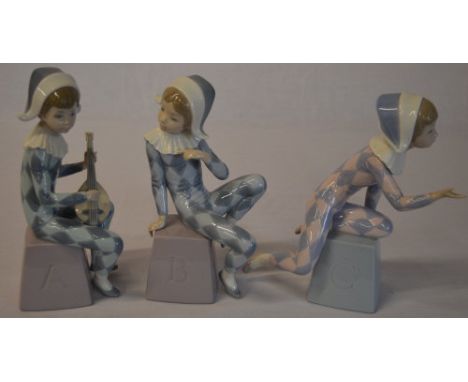 Set of three Lladro harlequin figures perched on bases titled A, B, C