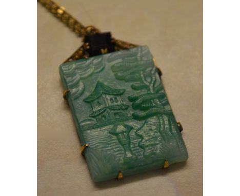 Ornate pinchbeck plaque drop pendant on a yellow metal chain depicting an Oriental pagoda scene in a light green jade style c