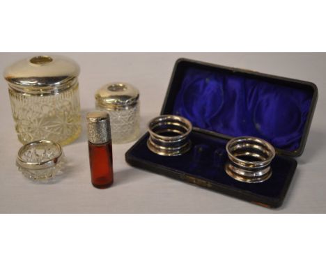 Silver topped/rimmed pots, pair of cased silver napkin rings and a small silver and ruby glass scent bottle (broken inside) (