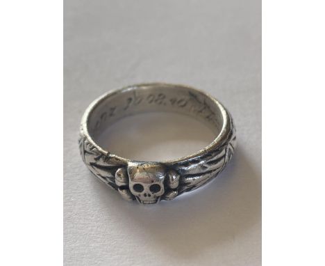 A GERMAN THIRD REICH HONOUR RING. A silver ring with central Totenkopf skull and bones, the band decorated with runic symbols