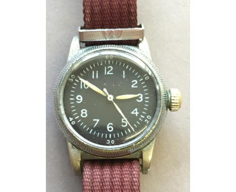 A SECOND WORLD WAR AMERICAN WRISTWATCH BY WALTHAM. A wristwatch with 2.5cm black backed dial with seconds sweep, on a fabric 