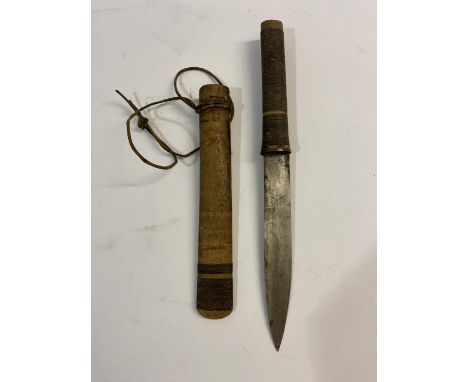 A TRIBAL KNIFE AND SCABBARD. A knife with a single edged slightly curved 19cm blade with woven bound wooden handle, the two p