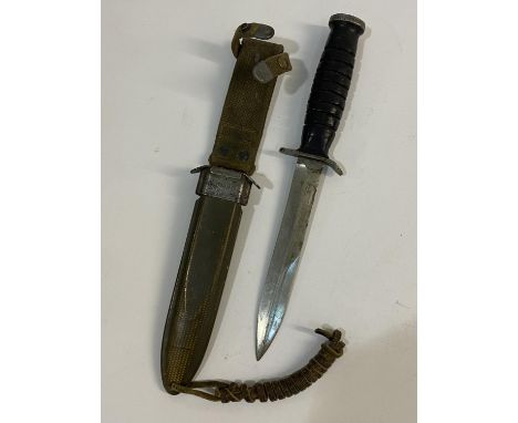 A US M3 FIGHTING KNIFE AND SCABBARD BY UTICA. With a 17cm pointed blade with double sided point, the cross guard marked 'US M