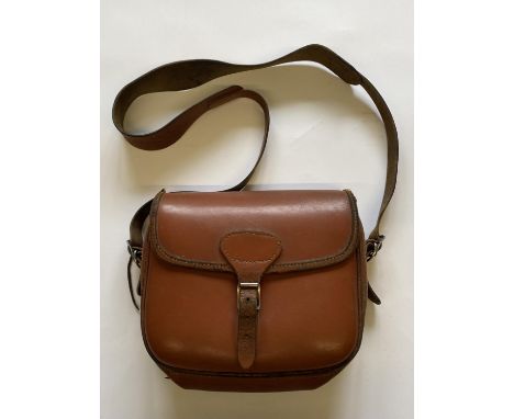 A BROWN LEATHER CARTRIDGE BAG. A light brown shoulder cartridge bag with buckle fastening and shoulder strap.