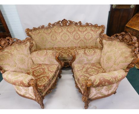 A Continental show-timber rococo style three piece suite, the frame profusely carved with shell, scrolls, flowers etc., uphol