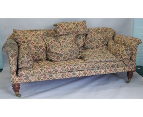A Victorian mahogany Chesterfield type sofa, upholstered in patterned fabric, on turned legs with brass castors (M)