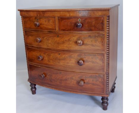 A Victorian mahogany bow fronted chest of drawers, with a crossbanded top above two short and three long drawers, each with t