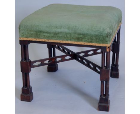 A mahogany foot stool, in the manner of Thomas Chippendale, with pilaster column supports, pierced X-shaped stretcher and blo