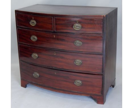 An early 19thC mahogany bow fronted chest of drawers, the caddy top with an ebony strung inner border, above two short and th