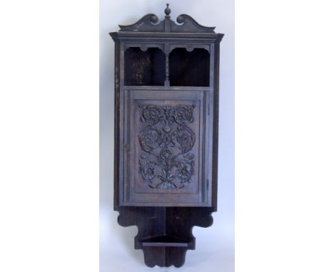 A late 19thC carved oak corner cabinet, with a shaped cornice above a recess, the door enclosing a single shelf, 138cm high, 