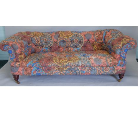 A Victorian Chesterfield sofa, upholstered in Middle Eastern style multi-coloured patterned fabric, with a buttoned back, arm