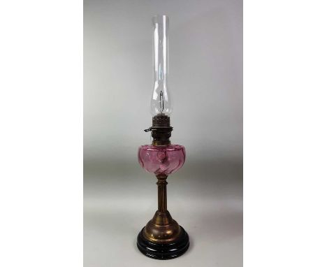 VICTORIAN OIL LAMP, with columned pedestal, cranberry glass reservoir and glass funnel71cm high overall