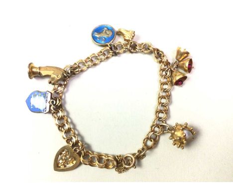 GOLD CHARM BRACELET, IN NINE CARAT GOLD the chain marked for nine carat gold, the charms are in gilt metal and not gold, with