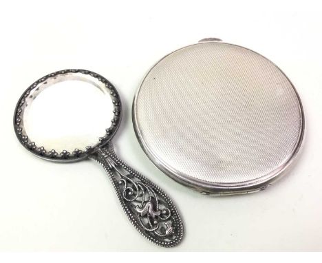 SILVER POWDER COMPACT, ALONG WITH A SMALL FILIGREE MIRROR the compact of circular form, with engine turned detailthe compact 