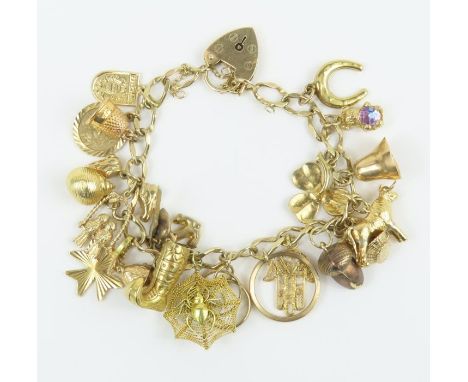 A 9ct gold charm bracelet with heart padlock, and charms attached, charms to include a wedding ring, a cobweb with spider, an