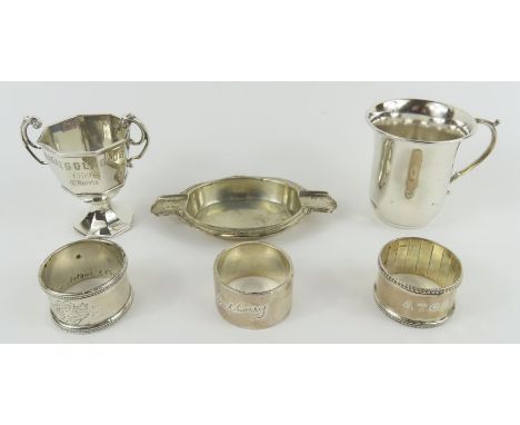 A small silver trophy cup, two silver napkin rings, a napkin ring marked 'stg silver' and a christening cup marked '925', 279