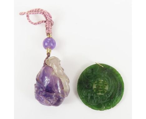 A 19th century Chinese amethyst carving of a creature on a rock with leaves, 5.2cm long, attached to a piece of silk with a b