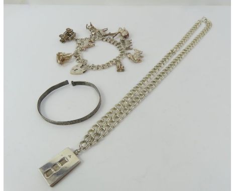 A silver ingot pendant on a double curb link chain marked 'sterling', 45cm long; a silver double curb link charm bracelet wit