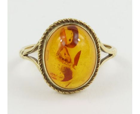 An unmarked single stone amber ring, finger size J, tests as 9ct gold, 1.5g gross