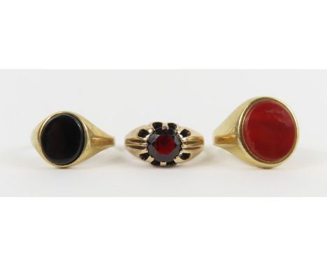 A 9ct carnelian set signet ring, finger size R; a 9ct signet ring claw set with a garnet, finger size Q 1/2 and a 9ct signet 