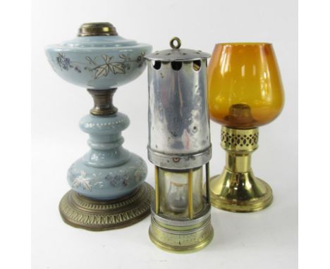 A brass and turquoise opaline glass oil lamp, with enamel floral overlay, 27cm high, brass storm lamp, 24cm high, and a miner