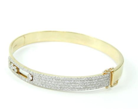 A yellow metal and diamond set bangle, three diamonds floating, on a snap clasp, stamped 14kt/1.75cts, 19.6g.