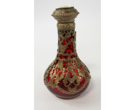 A Continental ruby glass scent bottle, with pierced foliate brass overlay, the hinged lid set with a cameo portrait of a gent