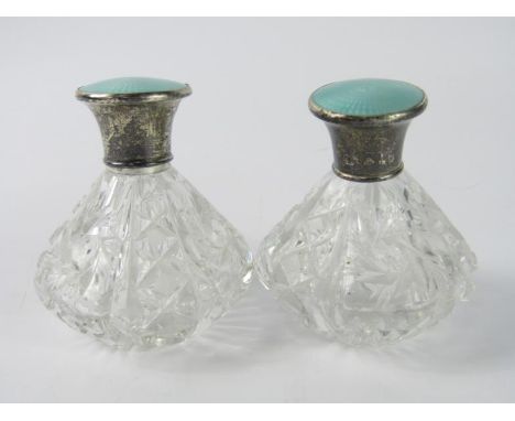 A pair of George V cut glass scent bottles, with silver and engine turned turquoise enamel lids, Birmingham 1929.