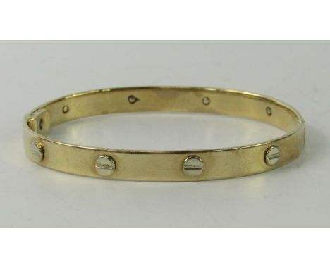 A 9ct gold bangle, with screw decoration at intervals, 21.5g.