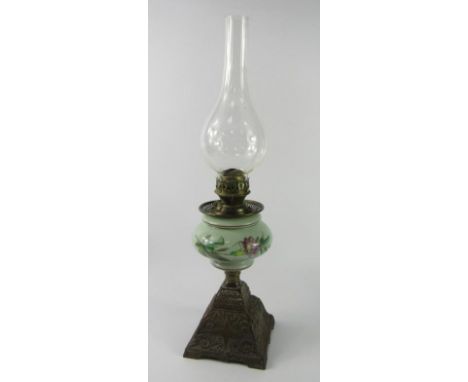 A Continental late 19thC cast iron oil lamp, with a green glass reservoir painted with flowers, 55cm high.