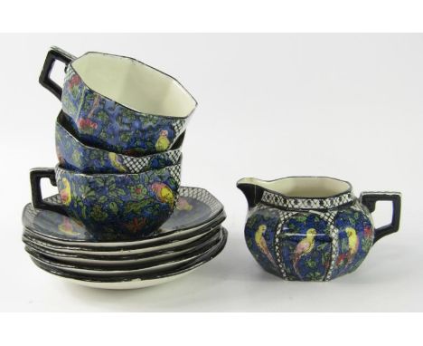 A Royal Doulton pottery part tea service, printed and painted with parrots against a blue ground, D4031, comprising cream jug