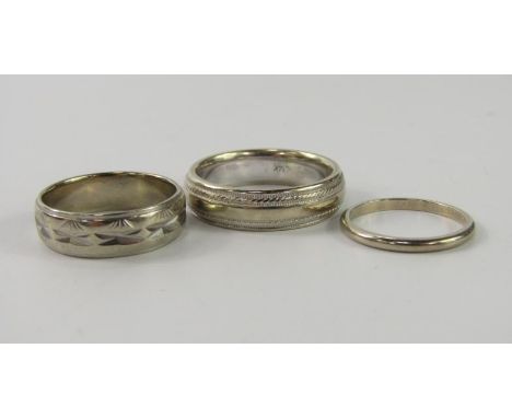 A white metal wedding band, stamped 14K, size T, another size K, 11.1g, and a third band, stamped 10K, size 0, 4.5g. (3)