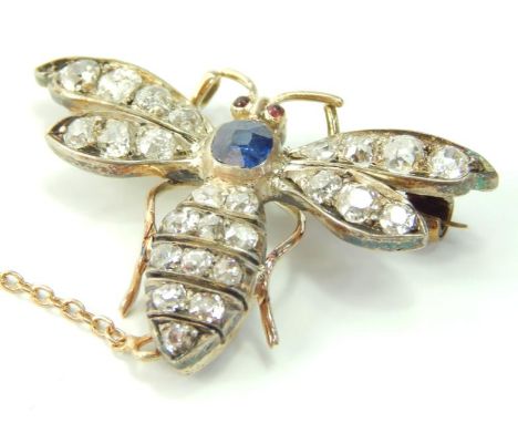 A diamond and gem set yellow and white metal insect brooch, the thorax set with a sapphire, cabouchon ruby eyes, on a safety 