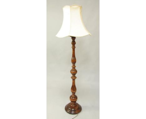 A baluster turned oak standard lamp, with a cream floral shade, 180cm high.